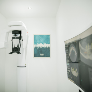 Dental CBCT scanning room with 3D jaw scan on screen