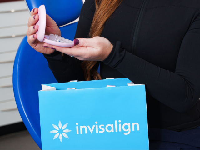 Woman holding an Invisalign aligner case with branded packaging