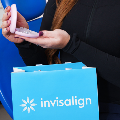 Woman holding an Invisalign aligner case with branded packaging