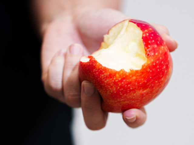 Hand holding a partly eaten red apple