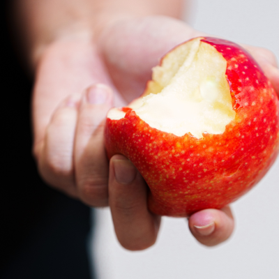 Hand holding a partly eaten red apple